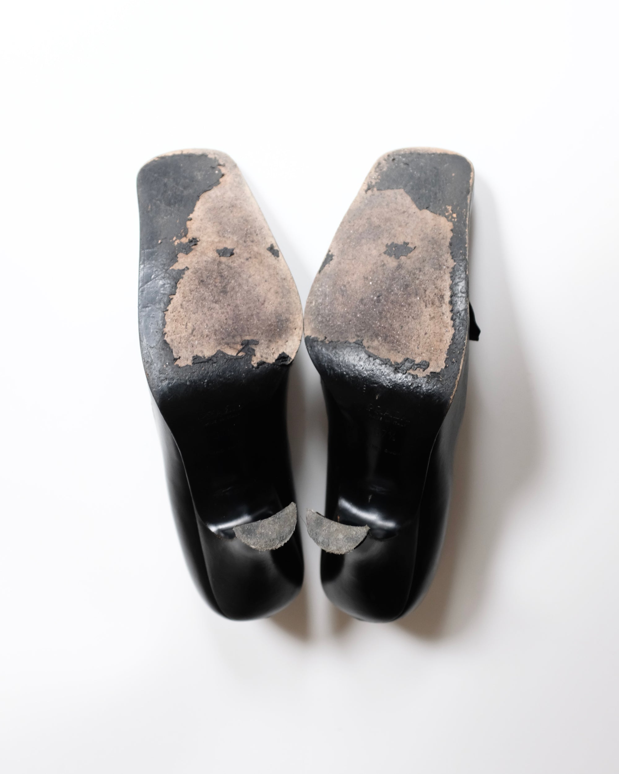 Black Prada shoes with rosette on a white background